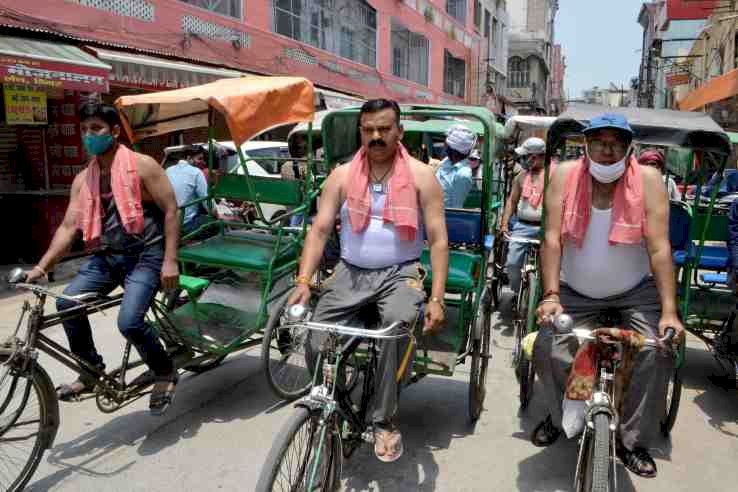 व्यापारियों ने रिक्शा चलाकर किया कोरोना कर्फ्यू विरोध